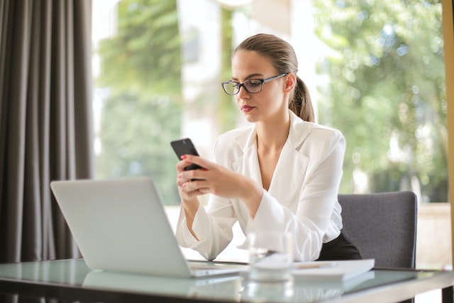 landlord sitting at their desk looking at their cellphone while texting